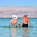 Casal tomando banho na praia no mar