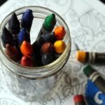 Pote de vidro com vários lápis coloridos de giz de cera