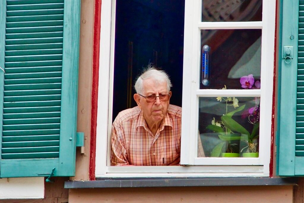 Onde Morar Depois Dos 60 Anos? 1 Senhor idoso olhando na janela de sua casa